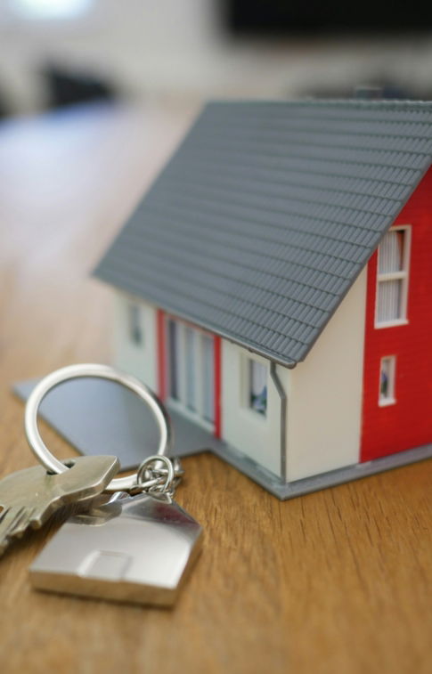 white and red wooden house miniature on brown table